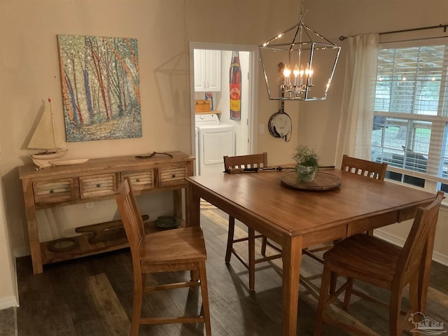 dining room featuring washer / dryer, wood finished floors, and an inviting chandelier