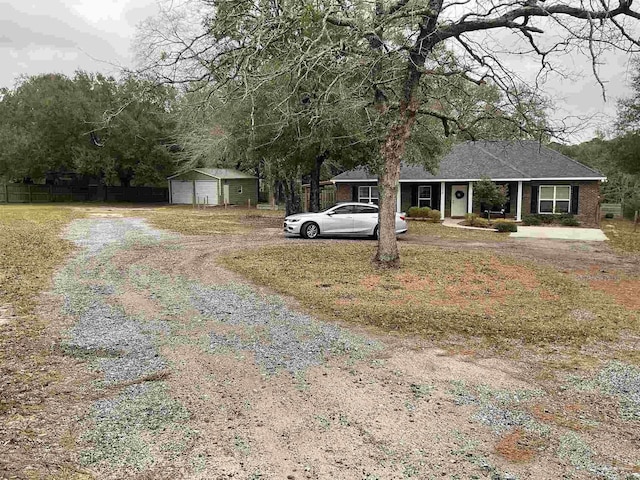 view of front facade with a detached garage and fence