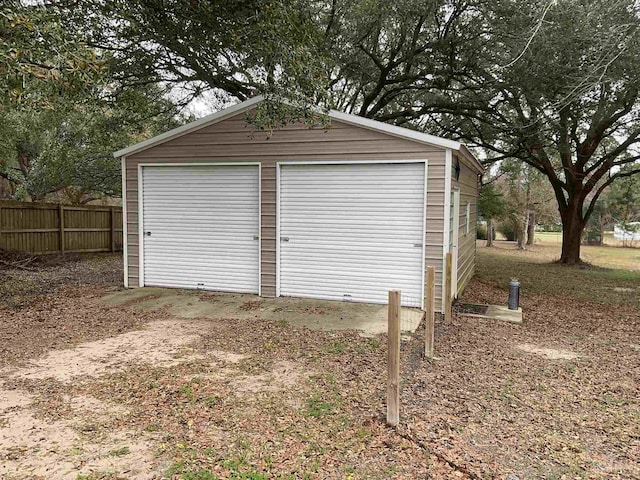 detached garage featuring fence