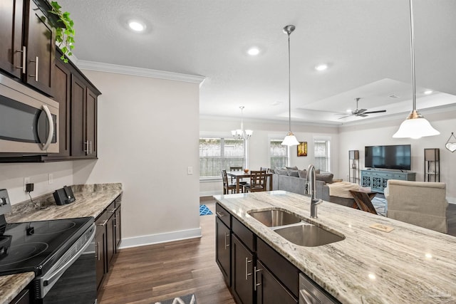 kitchen with dark wood finished floors, appliances with stainless steel finishes, ornamental molding, dark brown cabinets, and a sink