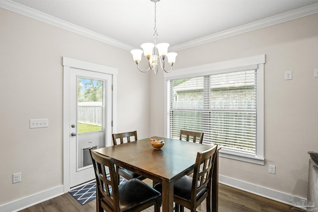 dining space with dark wood-type flooring, ornamental molding, baseboards, and an inviting chandelier