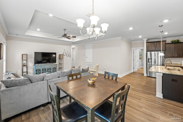 dining area with recessed lighting, light wood-style floors, ornamental molding, baseboards, and ceiling fan with notable chandelier