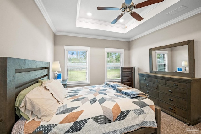 carpeted bedroom featuring ornamental molding, ceiling fan, a tray ceiling, and visible vents