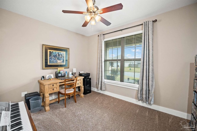 carpeted office space featuring a ceiling fan and baseboards