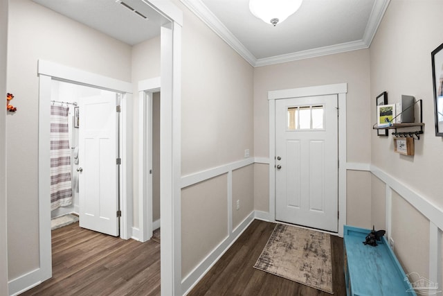 doorway to outside with ornamental molding, wainscoting, wood finished floors, and visible vents