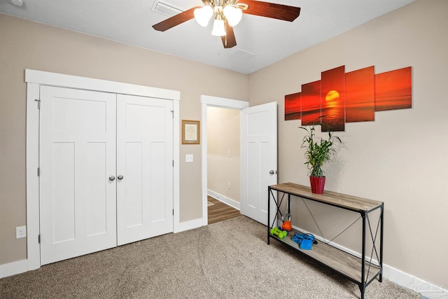 bedroom with ceiling fan, carpet flooring, visible vents, baseboards, and a closet