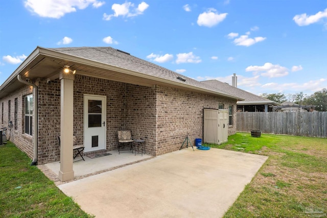 exterior space with a yard, brick siding, a patio area, and fence