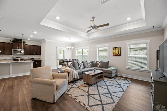 living area featuring dark wood-style floors, a tray ceiling, and plenty of natural light