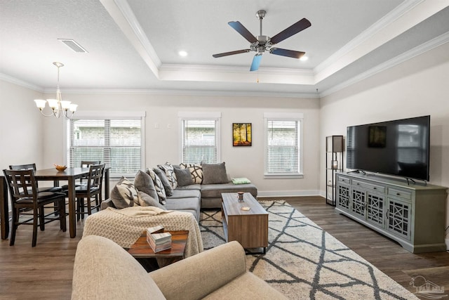 living room featuring visible vents, a tray ceiling, wood finished floors, and ornamental molding