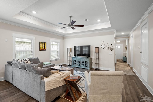 living area featuring dark wood-type flooring, a raised ceiling, visible vents, and baseboards