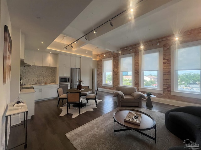 interior space featuring brick wall, baseboards, and dark wood finished floors