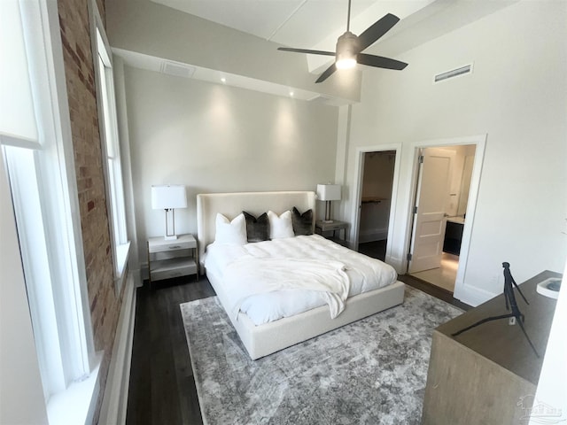 bedroom featuring ceiling fan, ensuite bath, wood finished floors, and visible vents