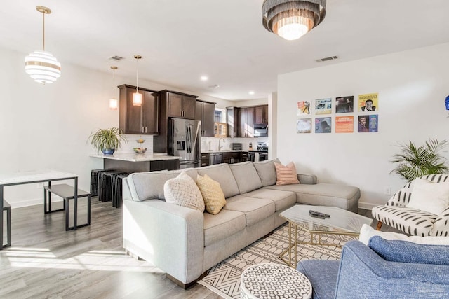 living room featuring light hardwood / wood-style floors and sink