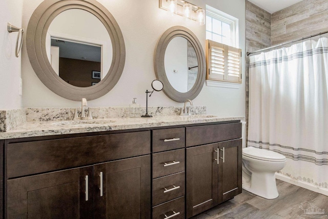 bathroom with hardwood / wood-style flooring, vanity, toilet, and walk in shower