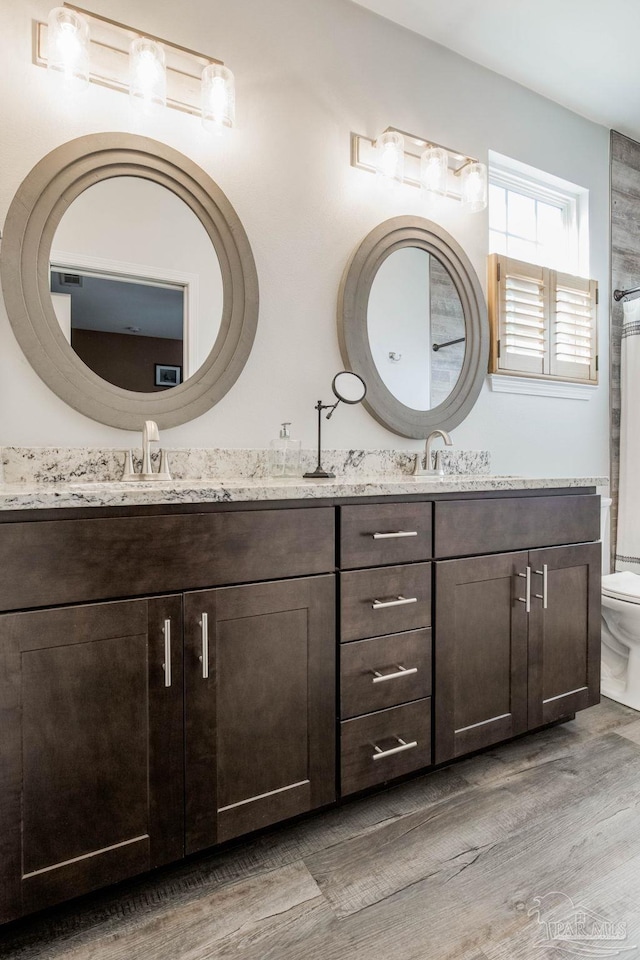 bathroom featuring toilet, vanity, and hardwood / wood-style flooring