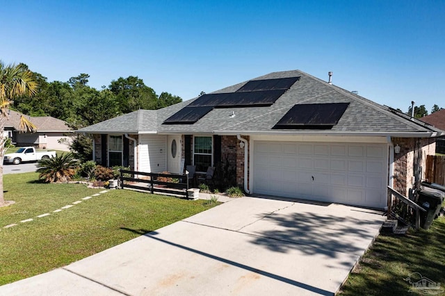 single story home featuring a garage, solar panels, driveway, roof with shingles, and a front lawn