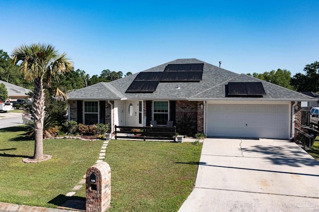 view of front facade featuring driveway, a front lawn, a shingled roof, and brick siding