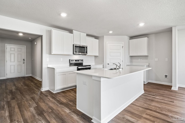 kitchen featuring a textured ceiling, dark wood-style flooring, a sink, stainless steel appliances, and baseboards