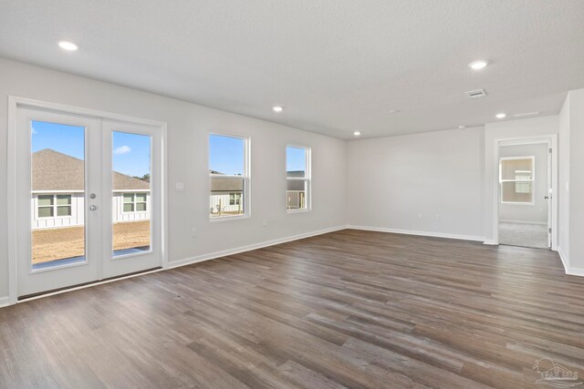 unfurnished living room with french doors, baseboards, dark wood-style floors, and plenty of natural light