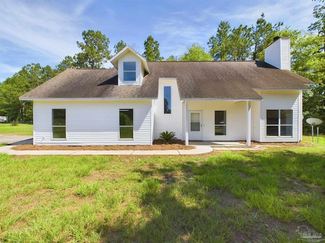 rear view of property featuring a yard and a patio area