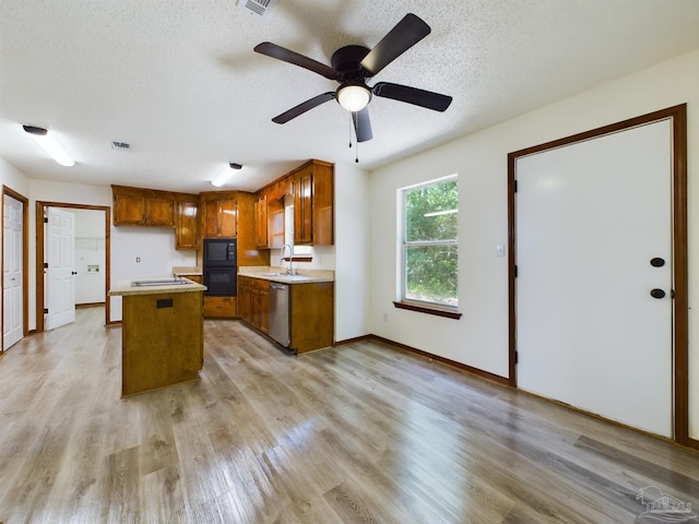 kitchen with sink, black appliances, light hardwood / wood-style floors, and a kitchen island