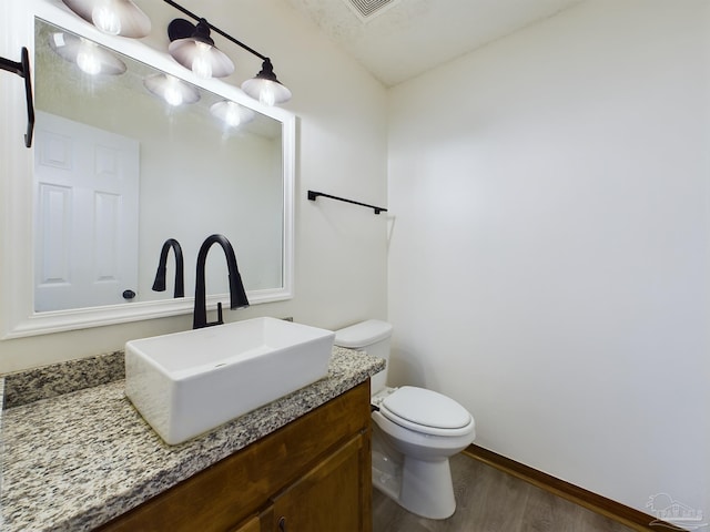 bathroom featuring hardwood / wood-style flooring, vanity, and toilet