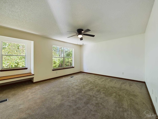 carpeted empty room with ceiling fan and a textured ceiling