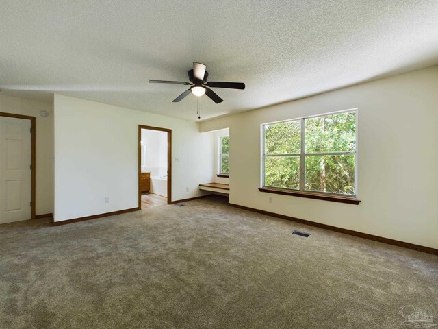 unfurnished bedroom with ceiling fan, ensuite bath, carpet, and a textured ceiling