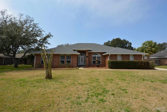 ranch-style house with brick siding, roof with shingles, and a front yard