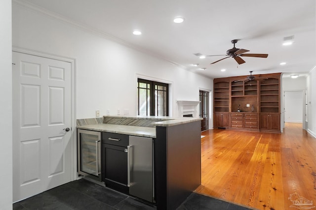 kitchen with ceiling fan, stainless steel refrigerator, beverage cooler, recessed lighting, and ornamental molding