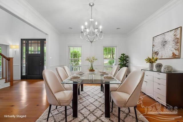 dining room featuring a chandelier, ornamental molding, wood finished floors, and stairway