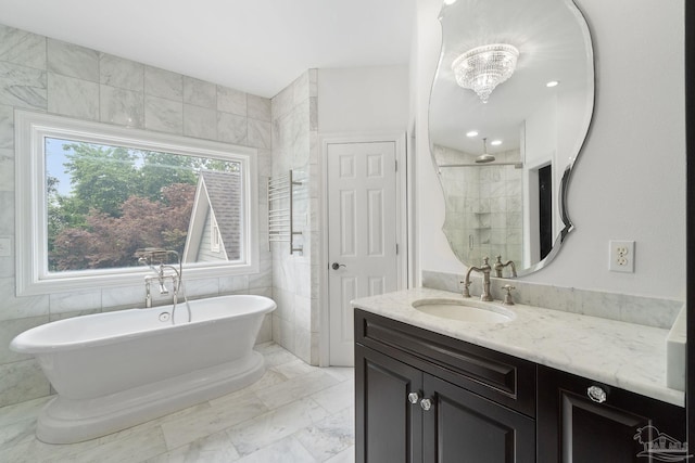 bathroom with vanity, marble finish floor, tile walls, a soaking tub, and a tile shower