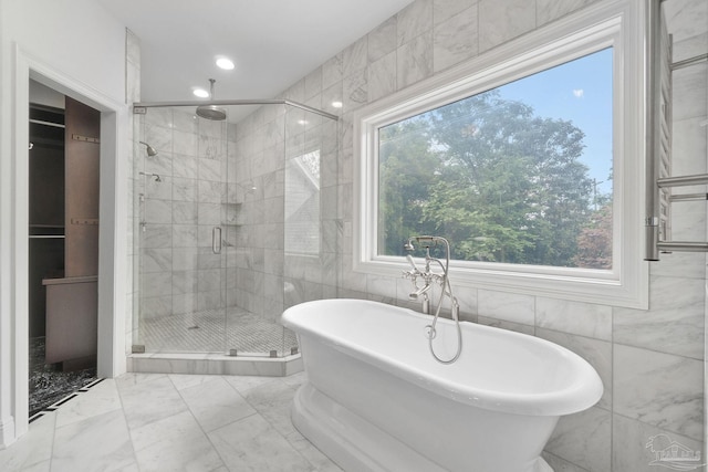 bathroom featuring a freestanding bath, tile walls, a shower stall, marble finish floor, and recessed lighting