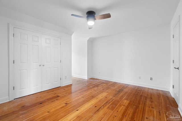 unfurnished bedroom with light wood-style floors, a ceiling fan, baseboards, and a closet
