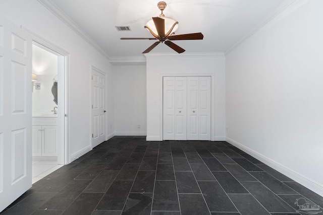 unfurnished bedroom featuring connected bathroom, a sink, visible vents, ornamental molding, and a closet