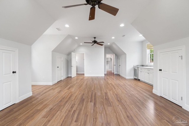 bonus room featuring a ceiling fan, visible vents, vaulted ceiling, baseboards, and light wood-style floors