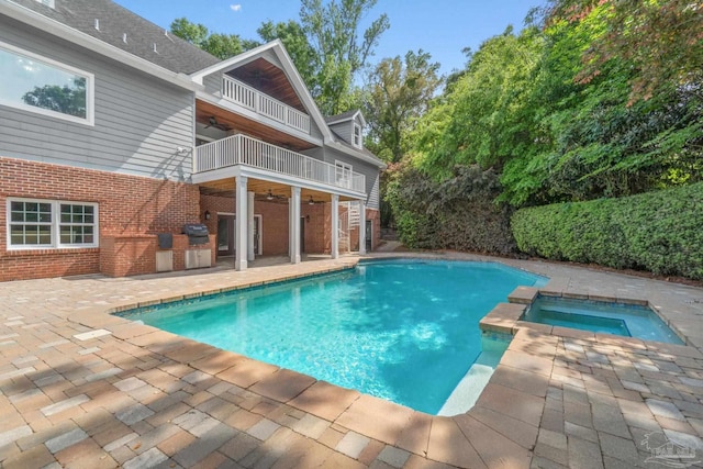 view of swimming pool with a patio, ceiling fan, a fenced in pool, and an in ground hot tub