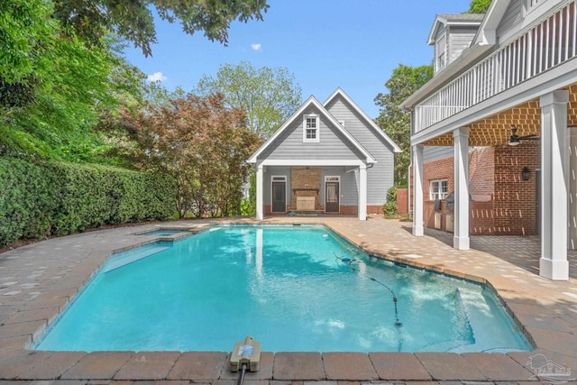 view of pool with an in ground hot tub, an outbuilding, an exterior structure, a fenced in pool, and a patio