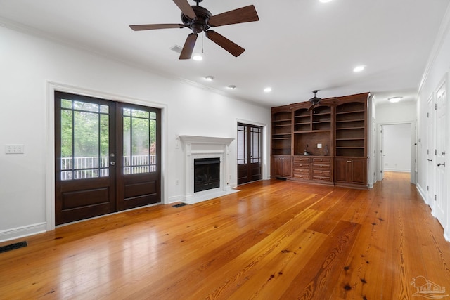 unfurnished living room featuring crown molding, visible vents, a fireplace with flush hearth, baseboards, and a ceiling fan