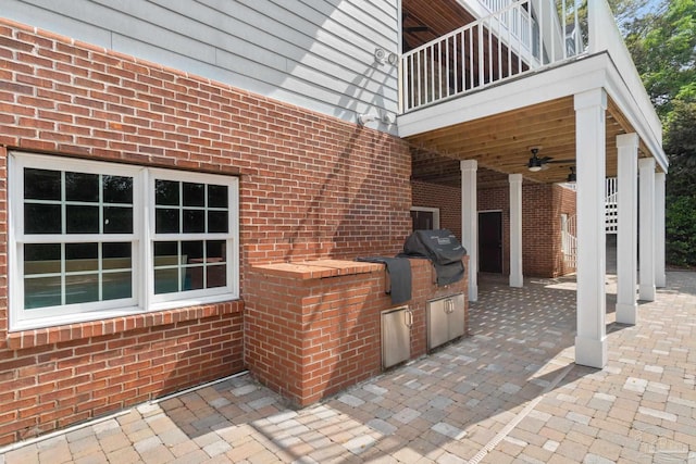 view of patio with a ceiling fan, area for grilling, and a balcony