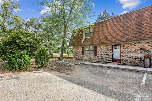 2707 E De Soto St, Pensacola, FL 32503 - exterior space featuring a shingled roof, brick siding, and mansard roof