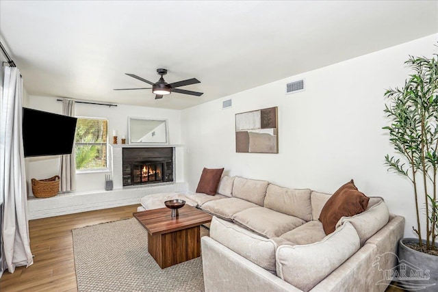 2707 E De Soto St, Pensacola, FL 32503 - living area with light wood-style floors, visible vents, a lit fireplace, and a ceiling fan