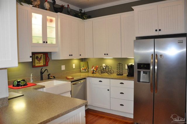 4565 Forsyth St, Bagdad, FL 32583 - kitchen featuring appliances with stainless steel finishes, a sink, crown molding, white cabinets, and glass insert cabinets