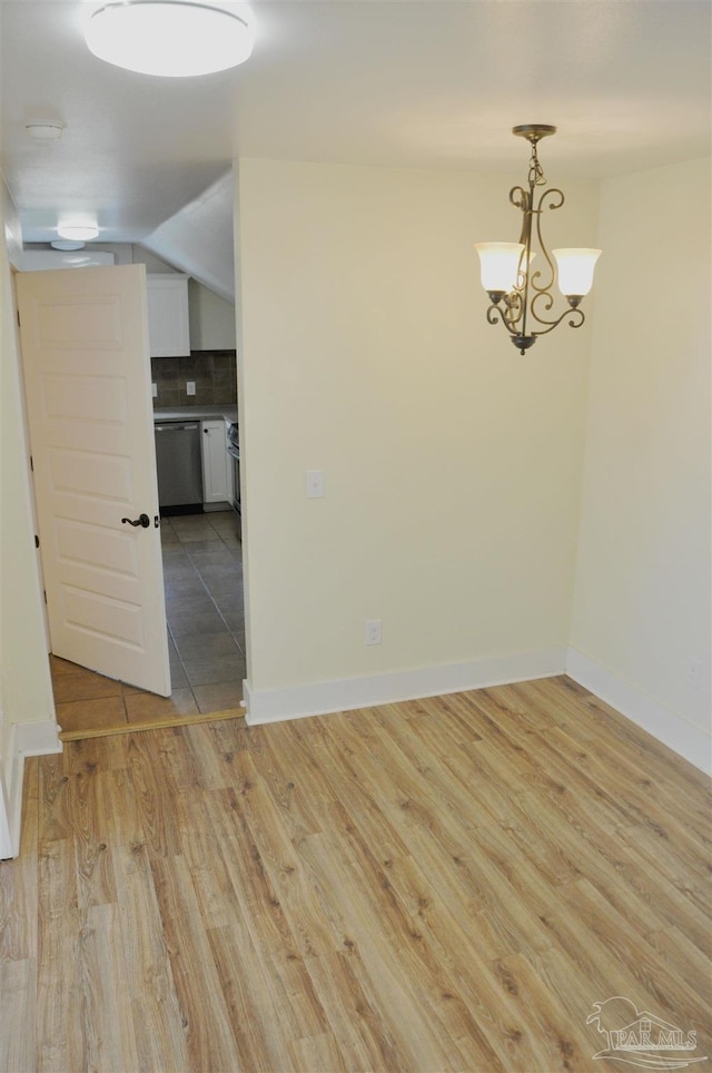 4565 Forsyth St, Bagdad, FL 32583 - empty room with light wood-style flooring, a chandelier, a smoke detector, baseboards, and vaulted ceiling