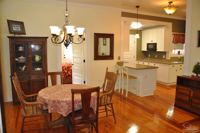 4565 Forsyth St, Bagdad, FL 32583 - dining room with wood finished floors, a chandelier, and ornamental molding