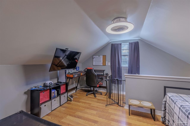 bedroom featuring baseboards, wood finished floors, and vaulted ceiling