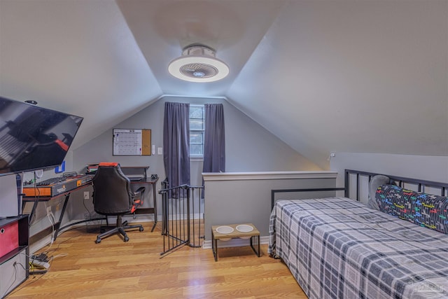 bedroom featuring baseboards, lofted ceiling, and wood finished floors
