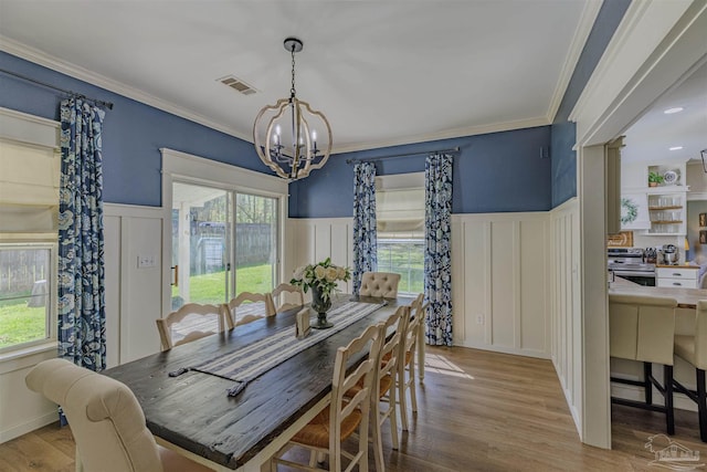 dining space featuring an inviting chandelier, plenty of natural light, wood finished floors, and visible vents