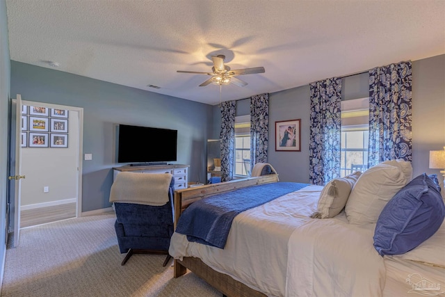 bedroom featuring multiple windows, baseboards, carpet floors, and a textured ceiling