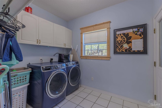 clothes washing area featuring baseboards, light tile patterned flooring, cabinet space, a textured ceiling, and independent washer and dryer